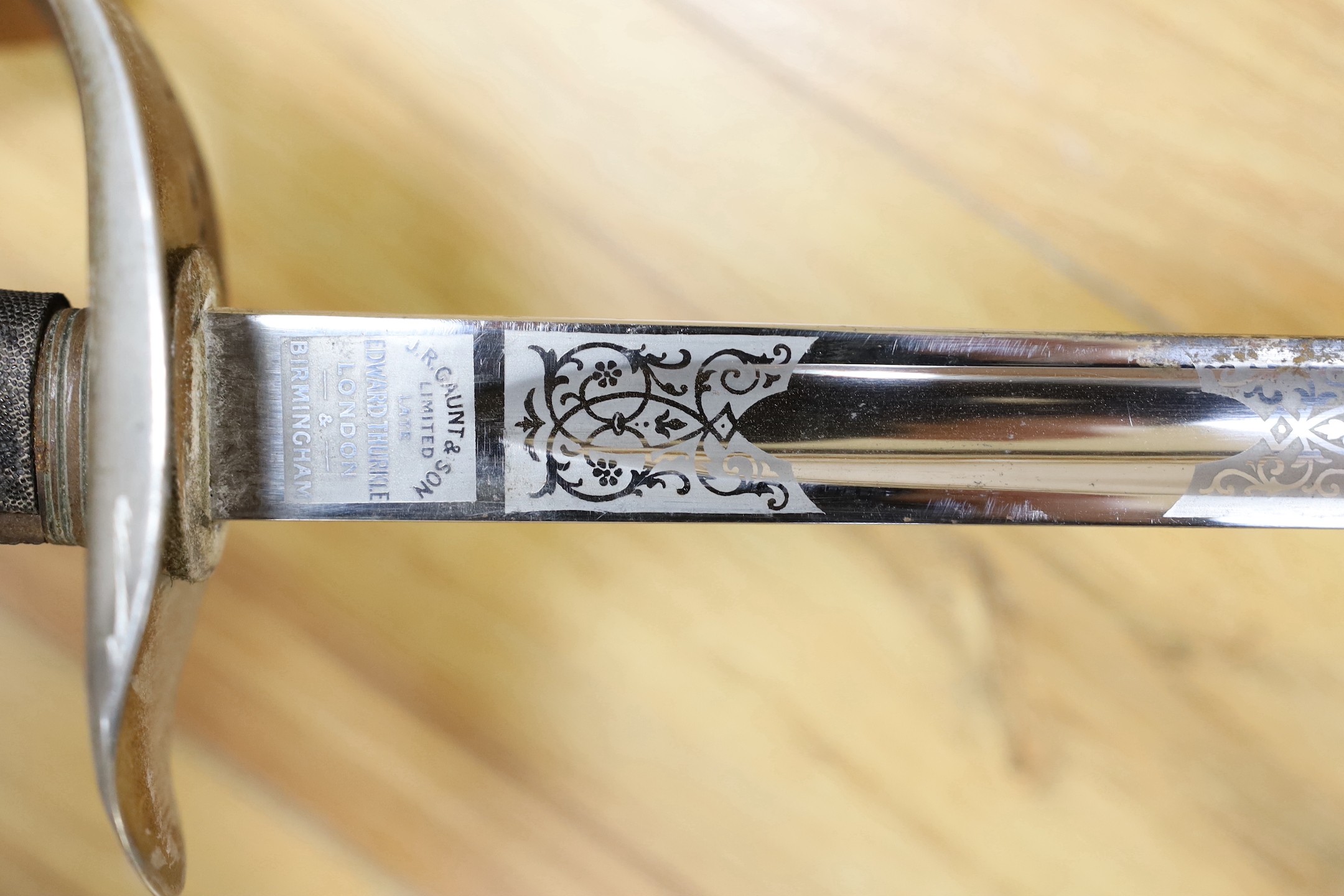 A George V military dress sword in brown leather covered scabbard, 102cm long, and a Middle Eastern dagger with carved and painted handle